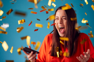 Celebrating,Young,Woman,With,Mobile,Phone,Winning,Prize,And,Showered